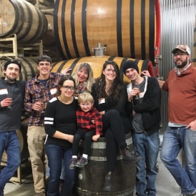 a group of people posing in front of a barrel