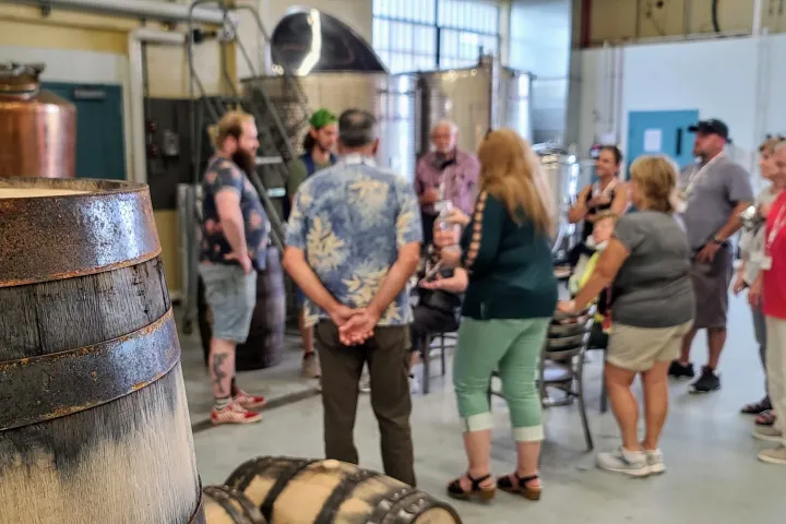 a group of people standing in front of a barrel