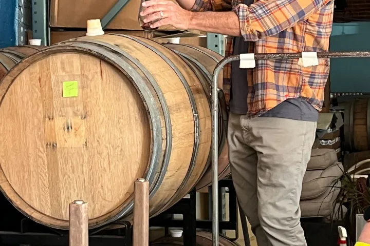 a man standing in front of a barrel