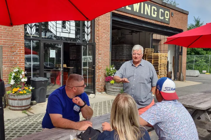 a group of people sitting at a table with an umbrella