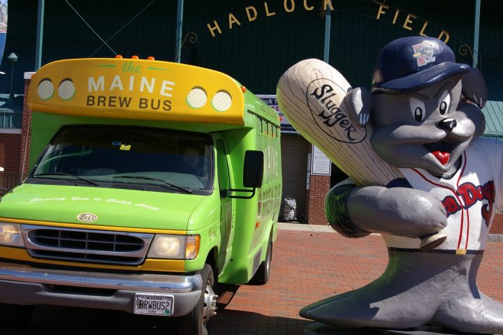 a green truck parked in front of a car