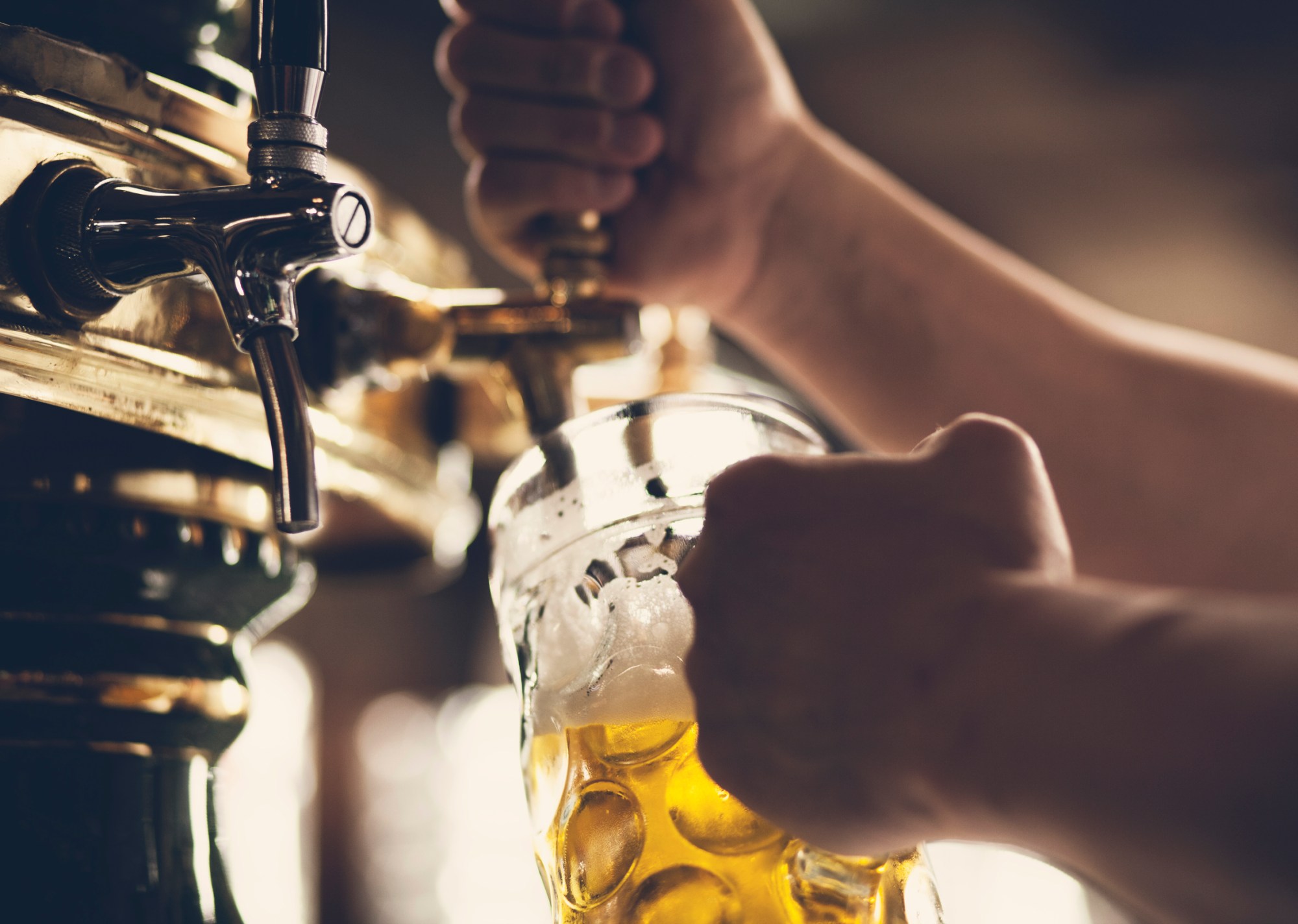 Beer a hand holding a glass of wine