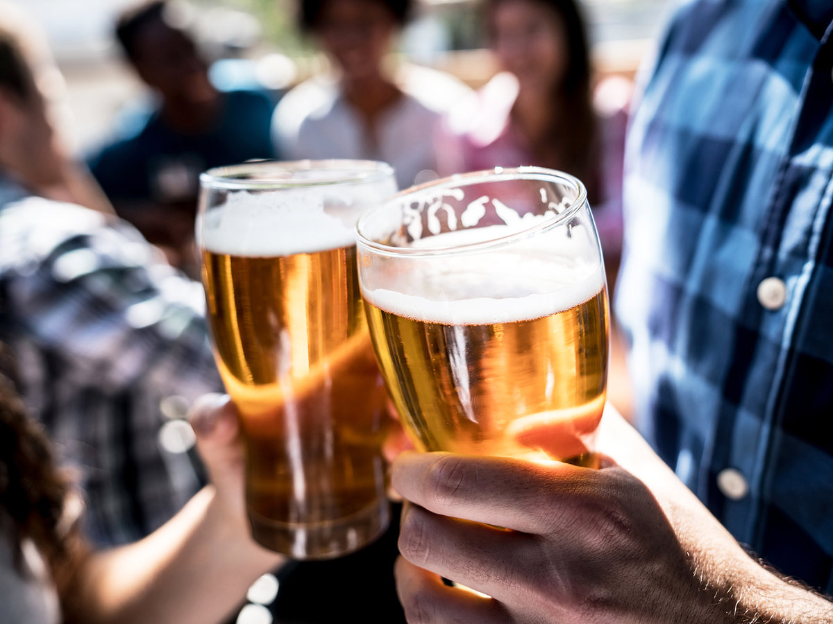 a close up of a person holding a glass of beer