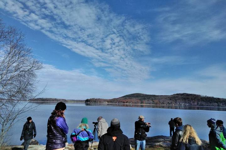 a group of people standing next to a body of water