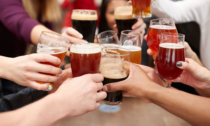 a woman holding a glass of beer on a table
