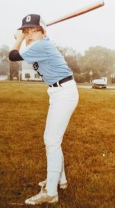 a baseball player holding a bat while standing next to home plate