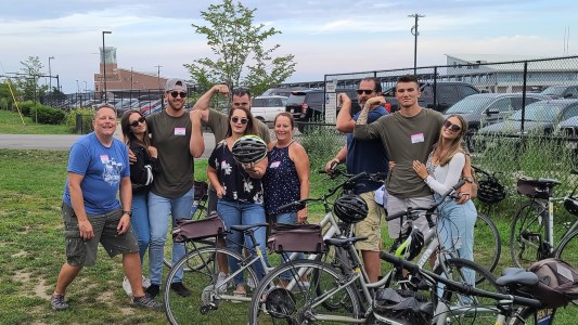 a group of people standing next to a bicycle