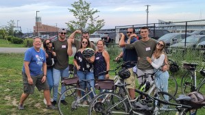 a group of people standing next to a bicycle