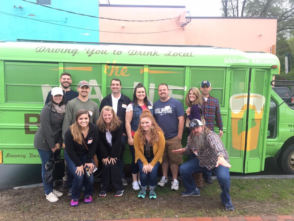 a group of people standing in front of a bus