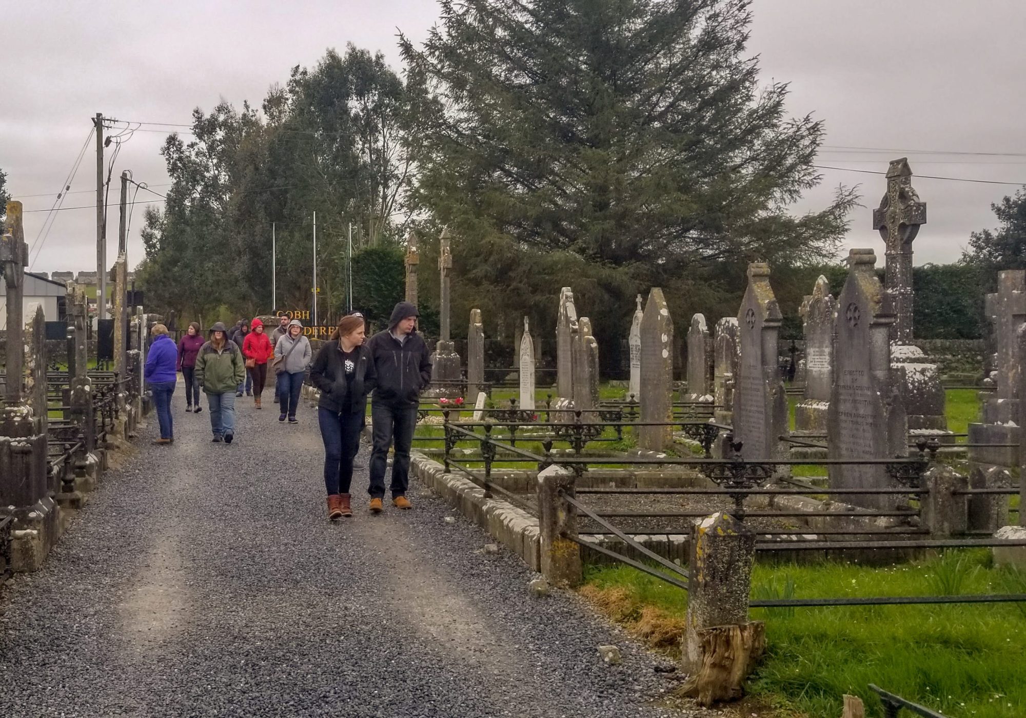 a group of people walking down a dirt road