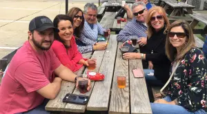 a group of people sitting around a wooden table