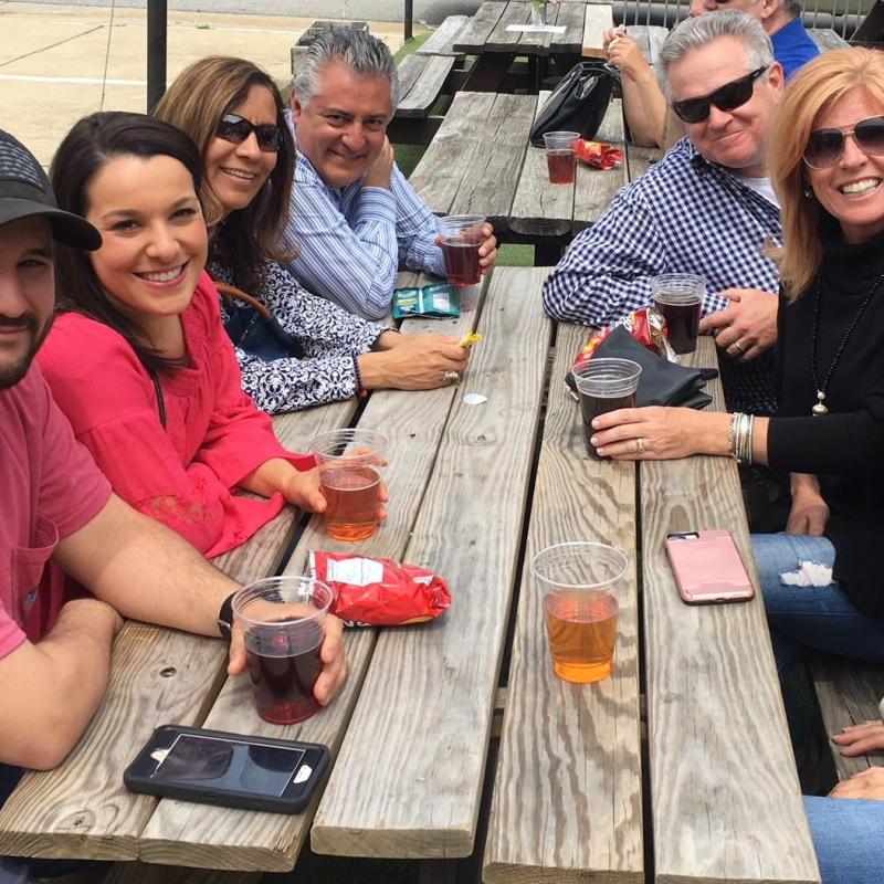 a group of people sitting around a wooden table
