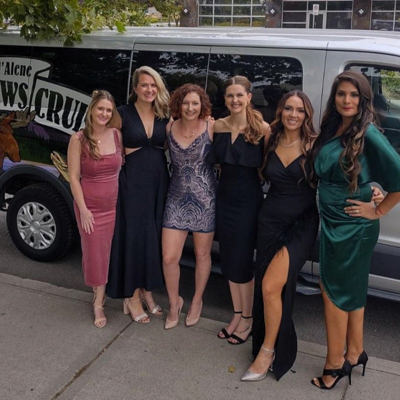 a group of people standing in front of a car posing for the camera