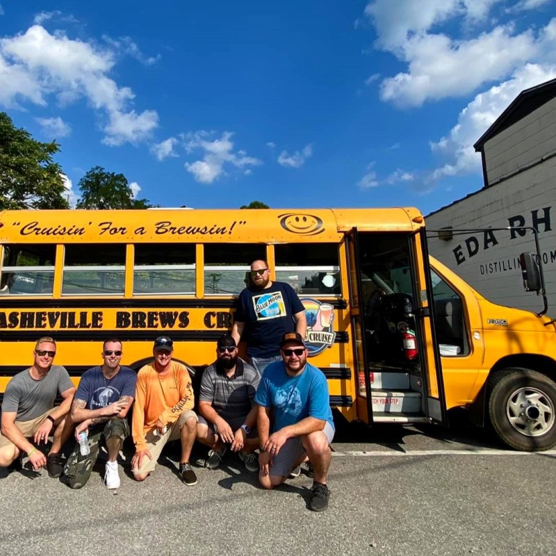 a group of people standing in front of a school bus