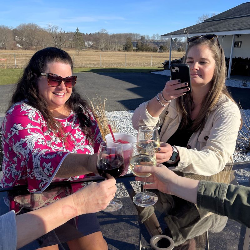 a group of people holding wine glasses and smiling at the camera