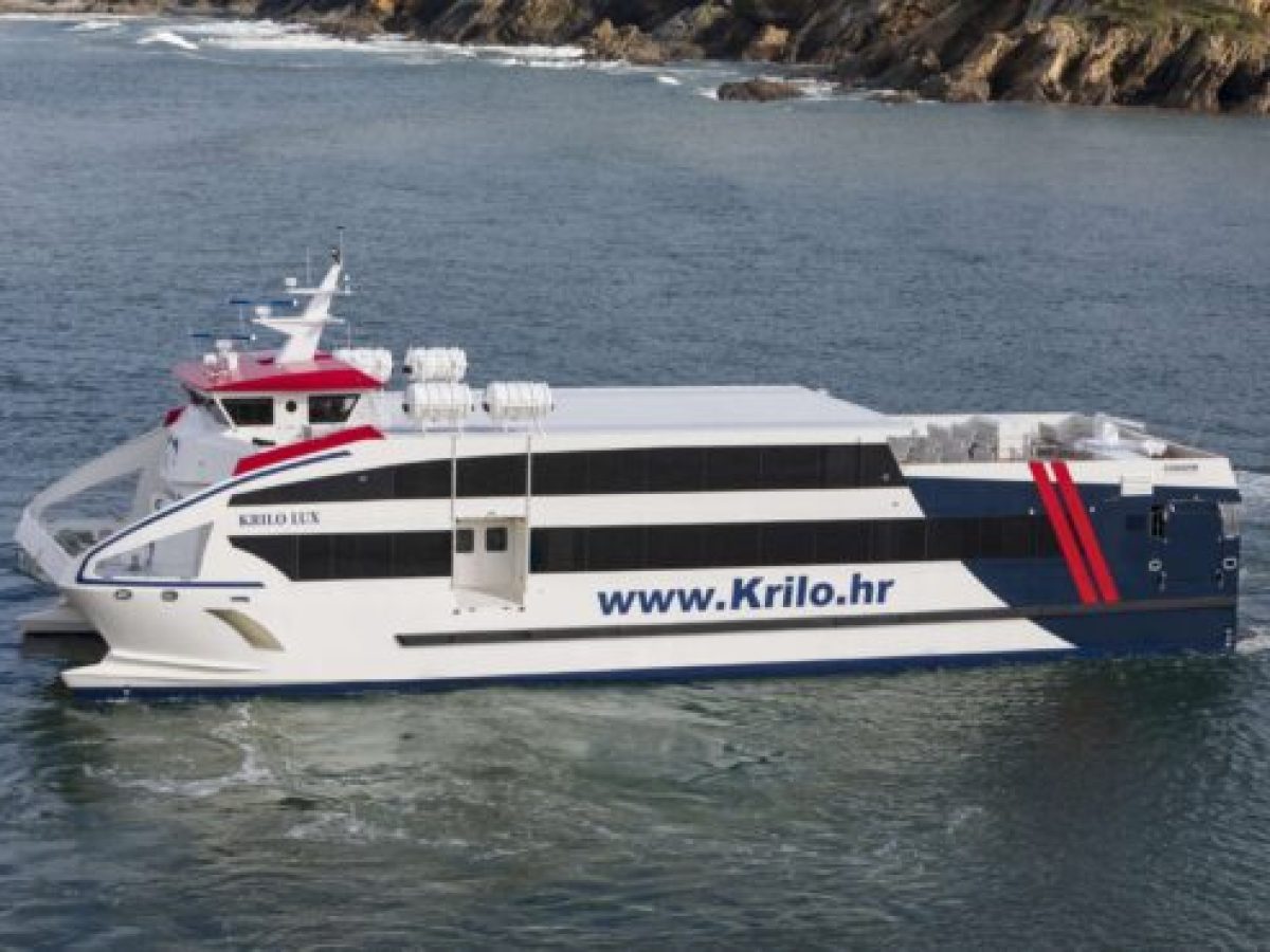 A ferry with 'Krilo.hr' on the side sails near rocky shores.