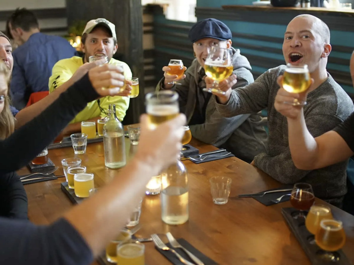 Group of people at a table raising glasses in a toast, smiling and joyful.