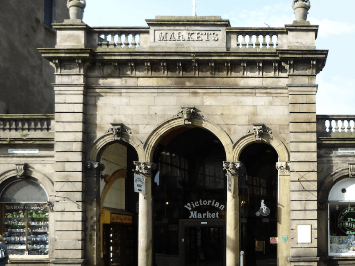 Stone building with arches labeled 'Victorian Market' entrance.