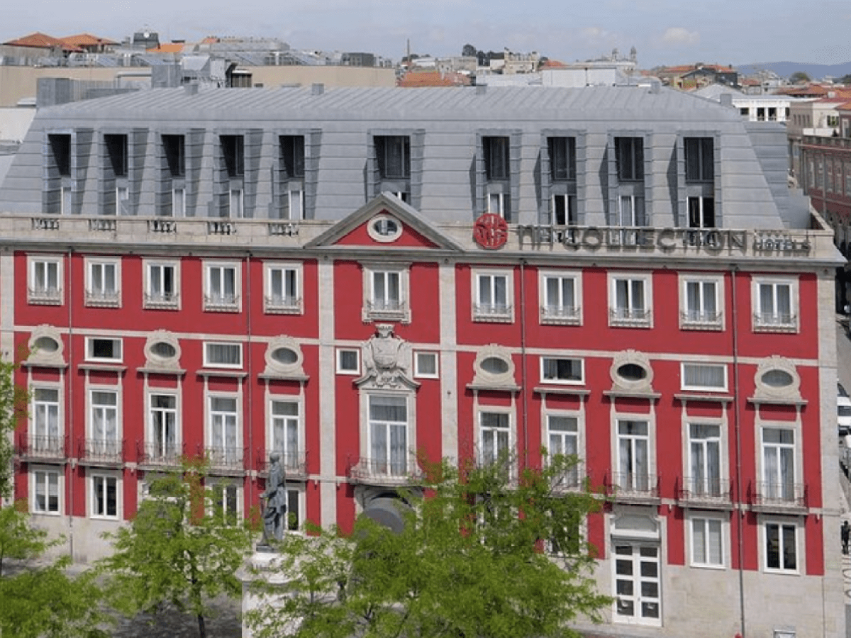 Red and gray-roofed building with multiple windows, labeled NH Collection.