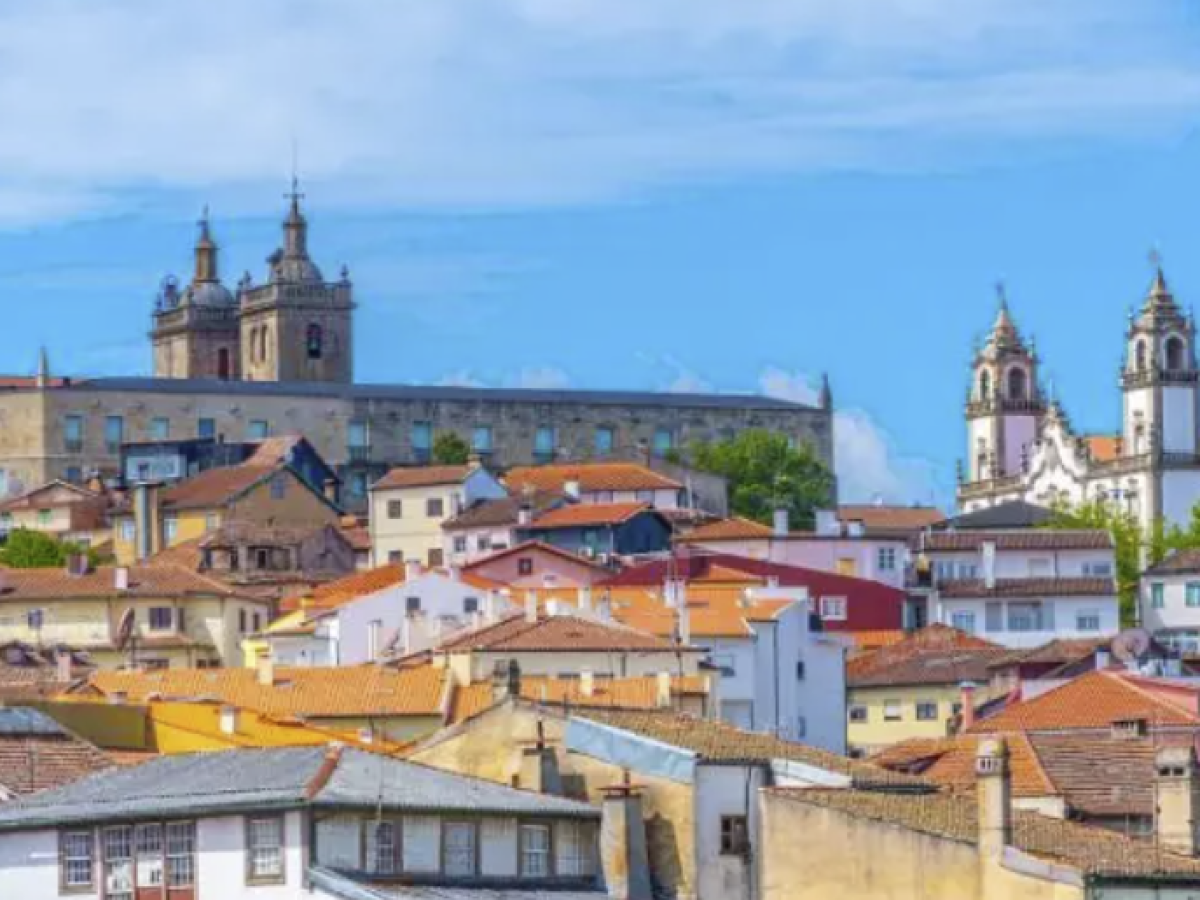 Colorful rooftops with churches and a blue sky in the background.
